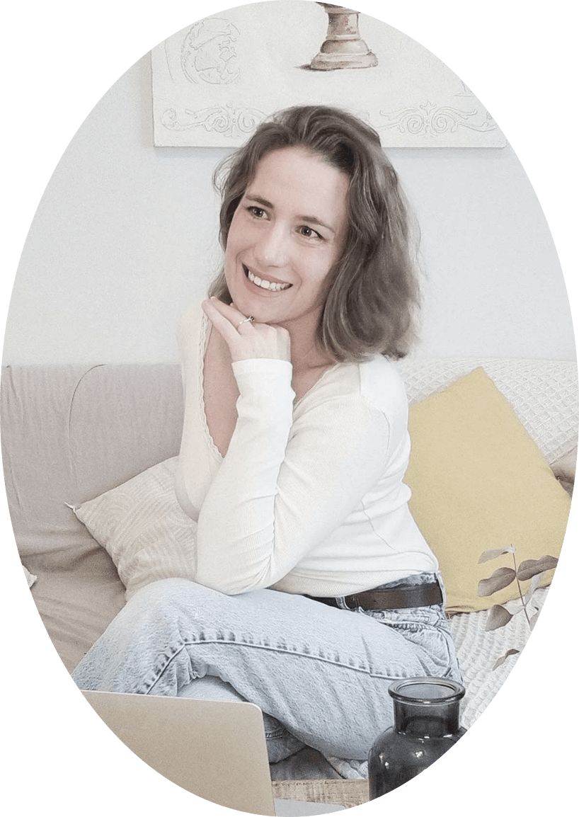 Portrait d'Audrey François, souriante, un ordinateur sur les genoux